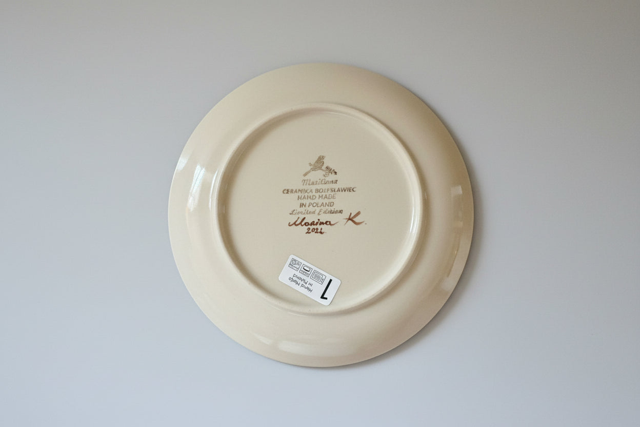White ceramic plate with branding on a red textured surface