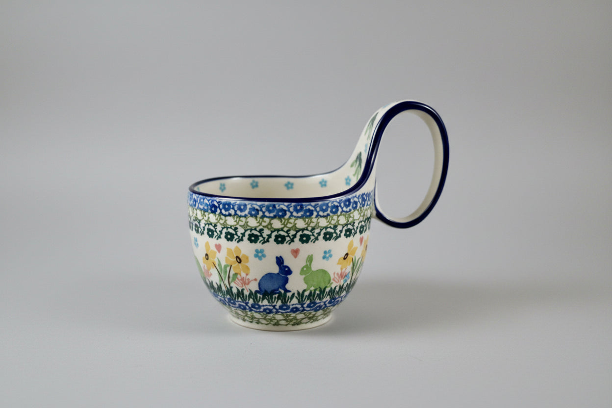 Decorative ceramic mug with floral and animal pattern on a lace doily