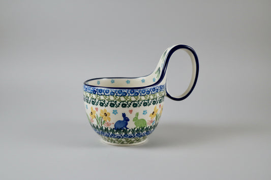 Decorative ceramic mug with floral and animal pattern on a lace doily