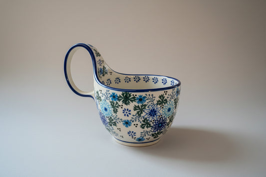 Ceramic pitcher with floral design on a lace tablecloth