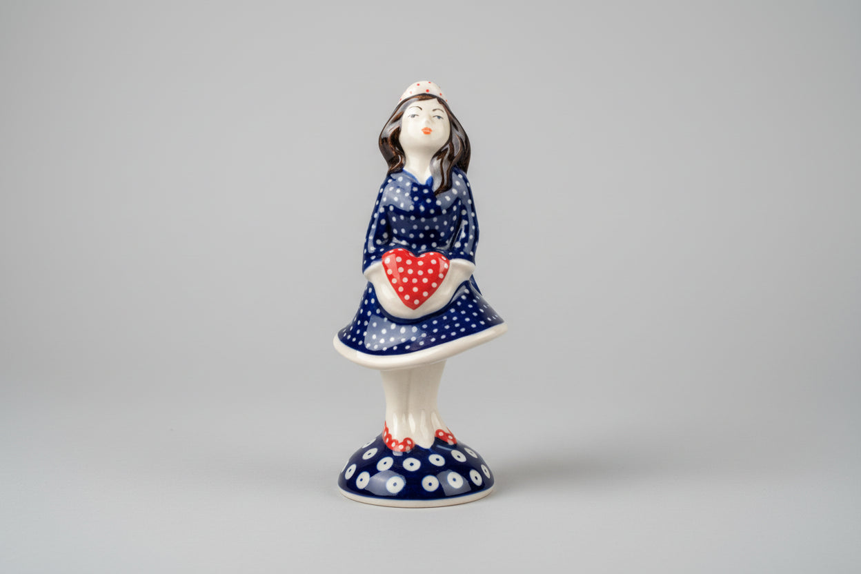 Ceramic figurine of a woman with a heart design on a lace tablecloth